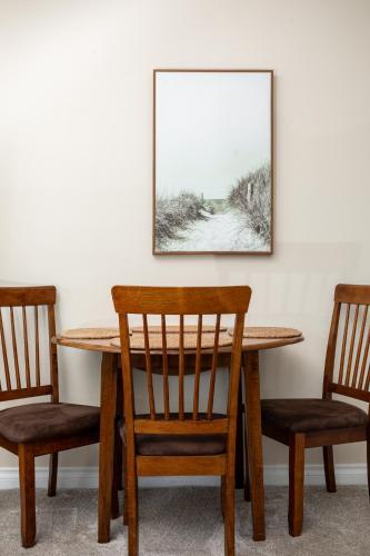 a wooden table with two chairs and a picture on the wall at Surreal Views #328 Beach Pool AC Hot Tub in Traverse City