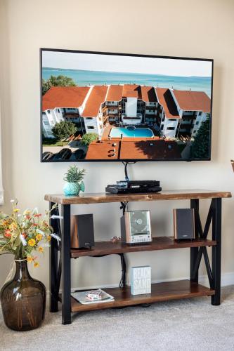 a living room with a tv on a wall at Surreal Views #328 Beach Pool AC Hot Tub in Traverse City