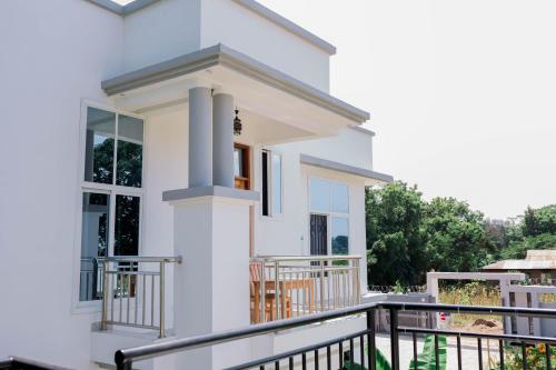 a white house with a balcony at Heim Villa in Kahe