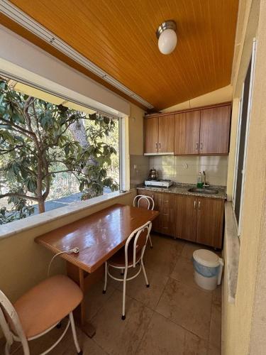 a kitchen with a wooden table and a window at Cicek Aile Pansiyonu in Burhaniye