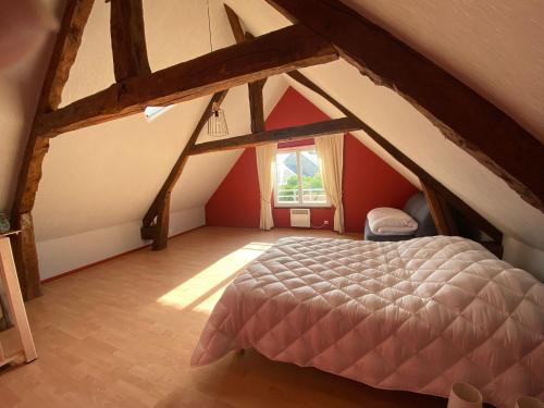 a attic bedroom with a bed and a window at Gîte des Rochers in Lonlay-lʼAbbaye