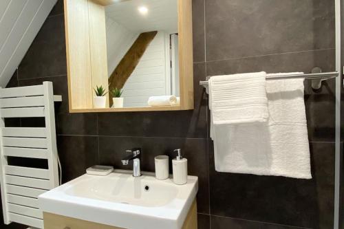une salle de bain avec un lavabo blanc et un miroir dans l'établissement Solidor - Vue mer à 1 minute de la plage !, à Saint-Malo