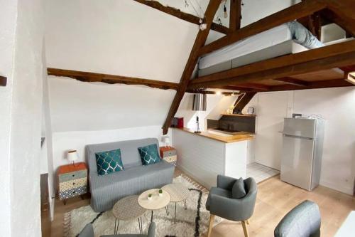 un salon avec un canapé et une cuisine dans l'établissement Solidor - Vue mer à 1 minute de la plage !, à Saint-Malo