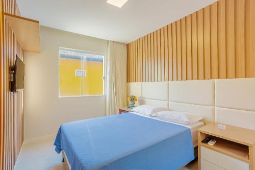 una camera da letto con un letto blu e una finestra di GB105 Porto Smeralda Guarajuba 2 suítes a 150m da praia a Guarajuba