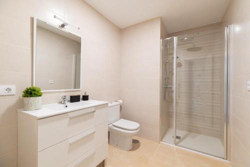 um banheiro branco com chuveiro e vaso sanitário em Gran Atico con terraza em Vigo