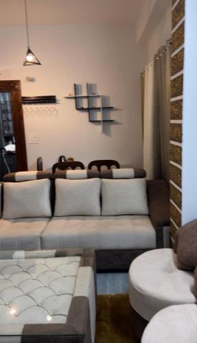 sala de estar con 2 sofás y sofá en Aathithi home stay, en Shogi