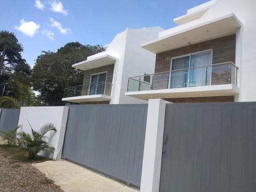 una casa bianca con un cancello e una recinzione di fantastica villa con piscina privata a Sosúa