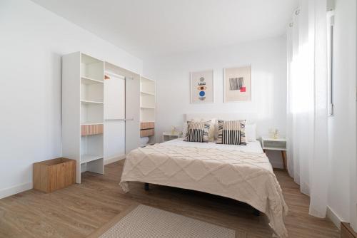 um quarto branco com uma cama e 2 almofadas em Gran Atico con terraza em Vigo