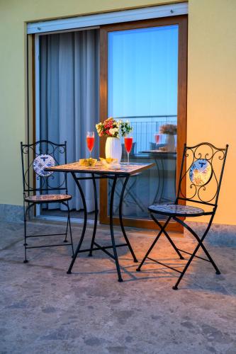 a table with two chairs and two glasses of wine at Exclusive B&B in Pizzo