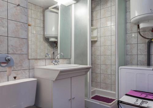une salle de bain avec un lavabo, des toilettes et un miroir dans l'établissement Bel appartement avec balcon, au Cap d'Agde