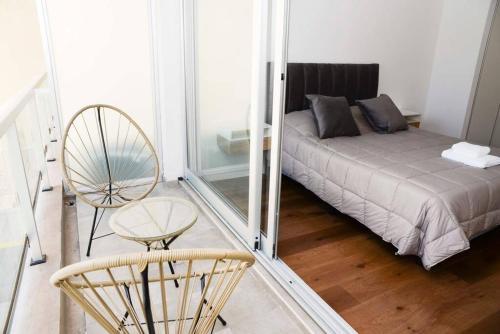 a room with a bed and a chair and a mirror at Belgrano amplio luminoso, cochera, WiFi, cerca River y Subte, 308 in Buenos Aires