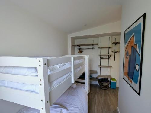 - un lit superposé blanc dans une petite chambre dans l'établissement Havre de paix Maison rénovée avec jardin, à Pornic