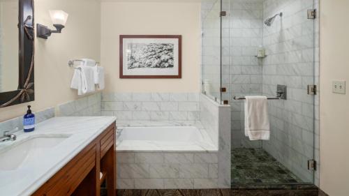 a bathroom with a tub and a sink and a shower at 1214 The Lodge At Spruce Peak Ski in Ski Out Studio Spruce Peak By Stowe Mountain Rentals in Stowe