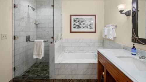 a bathroom with a tub and a sink and a shower at 1216 The Lodge At Spruce Peak Ski in Ski Out Studio Spruce Peak Village Views 2nd floor By Stowe Mountain Rentals in Stowe
