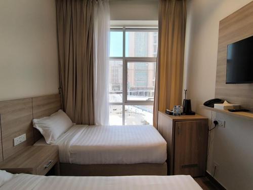 a hotel room with two beds and a window at Worth Elite Hotel in Makkah