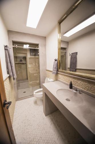 a bathroom with a sink and a toilet and a mirror at Descubre el lujo en el alma de San Miguel Allende in San Miguel de Allende