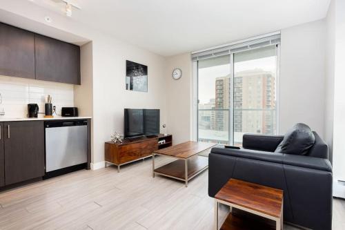 a living room with a black couch and a tv at Hendrix Luxury Apartments by Corporate Stays in Edmonton