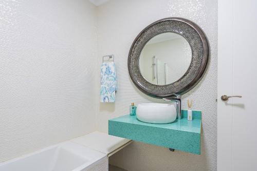 a bathroom with a sink and a mirror at Casa Mazagón con vistas al mar in Mazagón