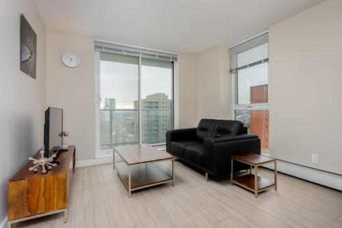 a living room with a black couch and a table at Hendrix Luxury Apartments by Corporate Stays in Edmonton