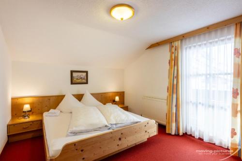 a bedroom with a large white bed and a window at Appartment Venter Bergwelt in Vent