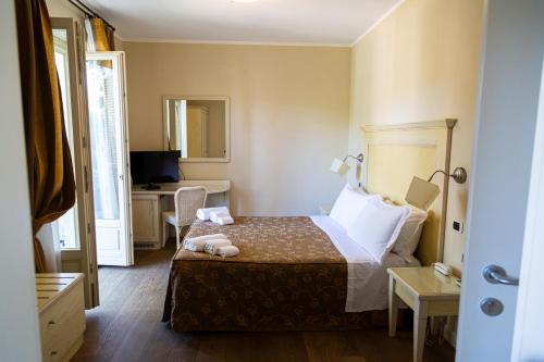 a hotel room with a bed and a television at Hotel Villa Tiziana in Marina di Pietrasanta