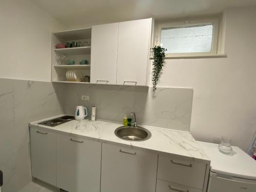 a white kitchen with a sink and a window at Ana one bedroom apartment, 1min from Old Town, Budva in Budva