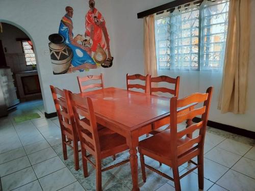 a wooden table and chairs in a room at A three bedroom holiday home in Ukunda