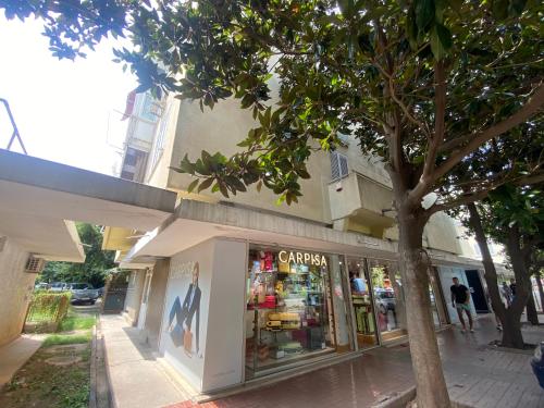 a store on the side of a street with a tree at Ana one bedroom apartment, 1min from Old Town, Budva in Budva