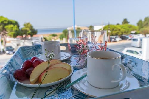 a tray with cups and plates of fruit on a table at Casa Mazagón con vistas al mar in Mazagón