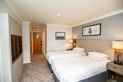 a hotel room with two beds and a television at Eastwood Hall in Eastwood