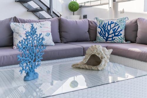 a living room with a purple couch and a glass table at Casa Mazagón con vistas al mar in Mazagón