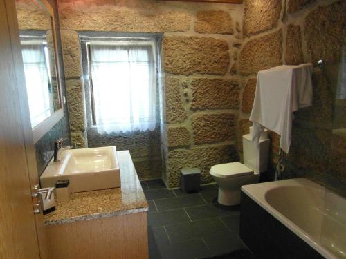 uma casa de banho em pedra com um lavatório e um WC em Casa da Bôcha em Cativelos