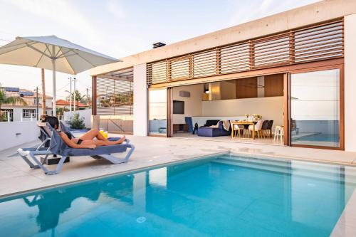 a woman laying in a chair next to a swimming pool at Lake House in Calheta