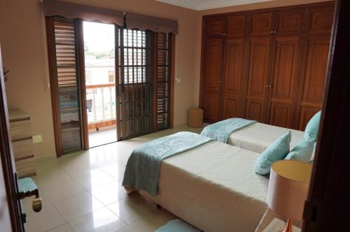 a bedroom with two beds and a large window at Apartamentos Los Reyes in Guamasa