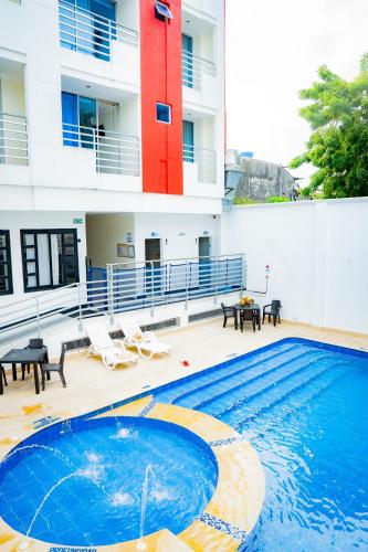 a swimming pool in front of a building at KALINA HOTEL in Girardot