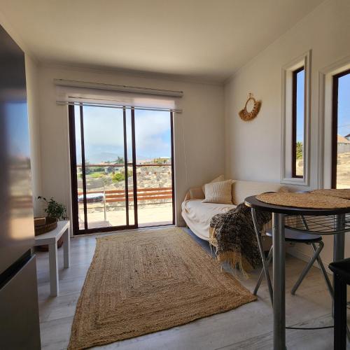 a living room with a couch and a table at Casa AltaVista Guanaqueros in Guanaqueros