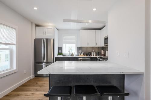 a white kitchen with a large white counter top at 3BR2Bth Parking Cambridge Boston W&D Subway AC in Somerville
