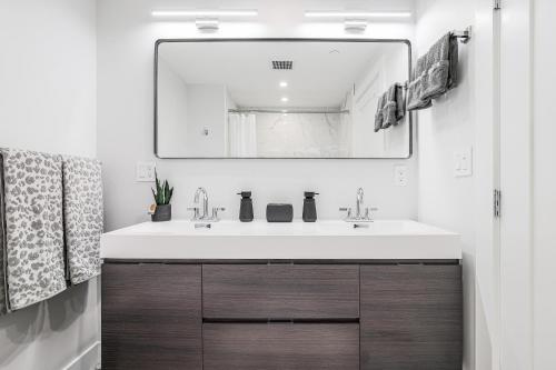 a bathroom with a white sink and a mirror at 3BR2Bth Parking Cambridge Boston W&D Subway AC in Somerville