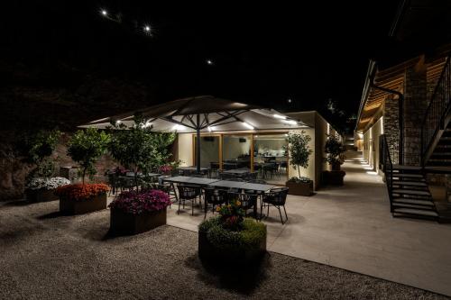 a table and chairs under an umbrella at night at Colago Private Villas Lake Garda in Toscolano Maderno