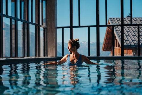 a woman in the water in a swimming pool at Hôtel Alparena & Spa - 4 étoiles in La Rosière