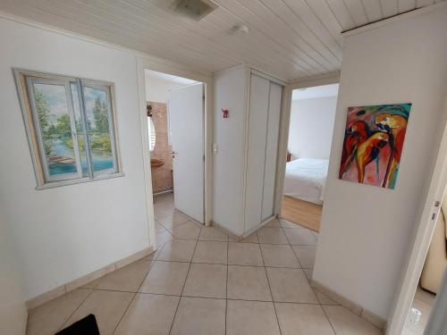 un couloir avec une chambre avec un lit et un tableau dans l'établissement Larmor-Plage T2 Kennedy, à Larmor-Plage