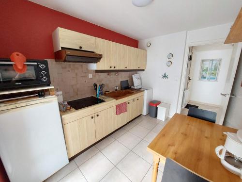 une cuisine avec des armoires en bois et un comptoir dans l'établissement Larmor-Plage T2 Kennedy, à Larmor-Plage