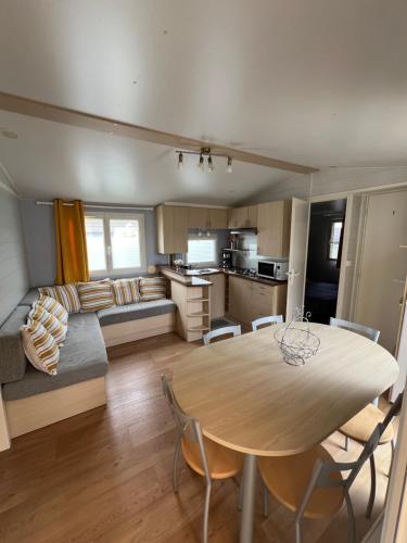 une cuisine et un salon avec une table et un canapé dans l'établissement Mobil home au camping 5 étoiles à Deauville, à Saint-Arnoult