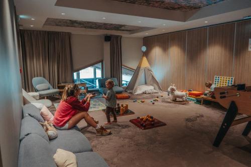 a group of children playing in a living room at Hôtel Alparena & Spa - 4 étoiles in La Rosière