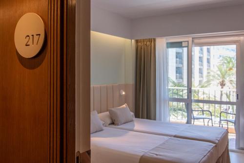 a hotel room with a bed and a window at Bordoy Cosmopolitan in Playa de Palma