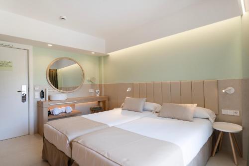 a bedroom with a large white bed and a mirror at Bordoy Cosmopolitan in Playa de Palma