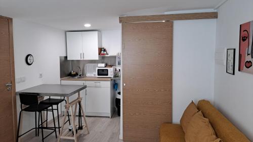 a small kitchen with a table and a couch in a room at Studio dAires in Coimbra
