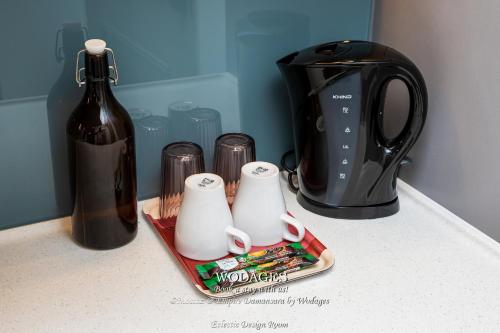 a counter top with a bottle of wine and a toaster at Mossaz at Empire Damansara by Wodages in Kuala Selangor