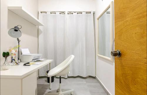 a bathroom with a desk and a white shower curtain at Bella Vista cozy-deluxe near Downtown center in Santo Domingo