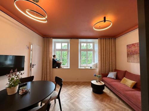 a living room with a red couch and a table at Apartament TAMAJA in Bielsko-Biala